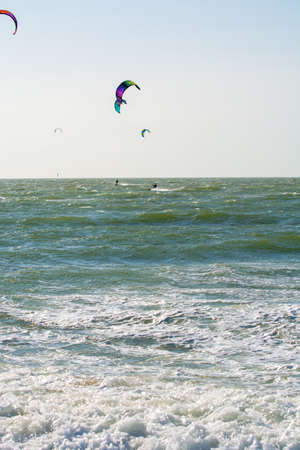 Water sport event, colorful kite surfers race in North Sea near Renesse, Zeeland, Netherlands