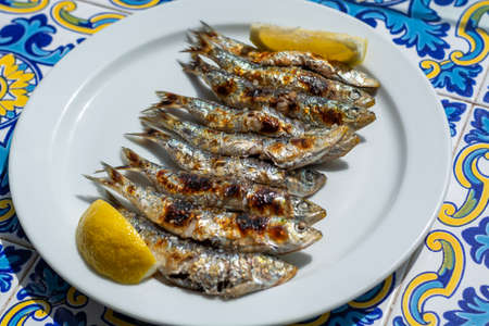 Sardines espeto, Malaga style fish on stick barbecue prepared on olive tree firewoods on beachの写真素材