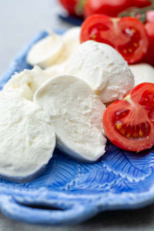 Cheese collection, fresh Italian soft mozzarella cheese in balls served with red ripe tomatoes close upの写真素材