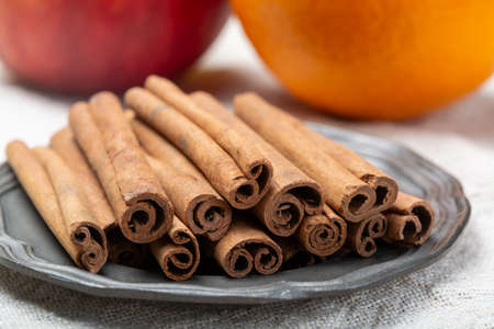 Winter food ingredient, dried aromatic cinnamon sticks on tin plate close up