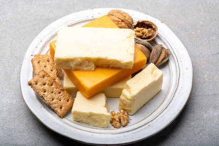 Cheese collection, matured and orange original British cheddar cheese in blocks served with crackers close upの写真素材