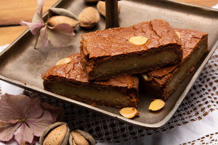 Fresh baked Dutch filled spicy cookies with almonds in autumn colors on dark wooden background close upの写真素材