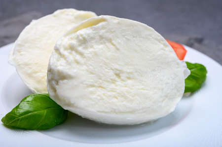 Cheese collection, soft white Italian mozzarella di bufala campana with fresh green basil leaves and...