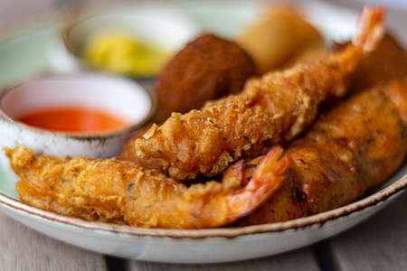Dutch snacks for beer or wine, tempura shrimps, skewered chicken, bitterballs and hot dip sauces macroの写真素材