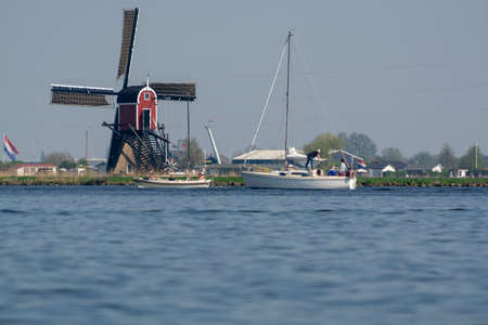 Waterways of North Holland and view on traditional Dutch wind mill, Dutch lifestyle landscape