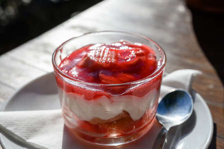 Sweet dessert, cheese cake with mousse and red prickly pears jam served in glassの写真素材