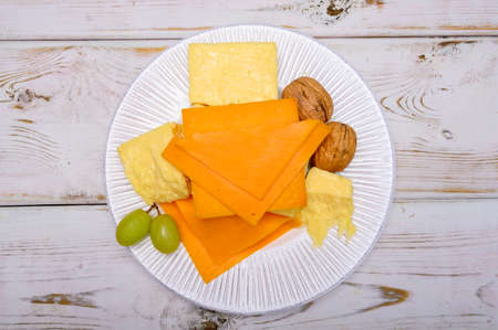 Cheese collection, blocks and slices of yellow and matures english cheddar cheese close upの写真素材