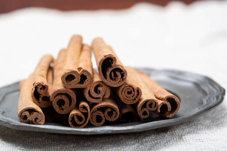 Winter food ingredient, dried aromatic cinnamon sticks on tin plate close upの写真素材