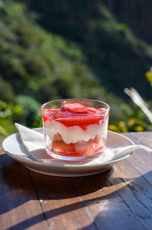 Sweet dessert, cheese cake with mousse and red prickly pears jam served in glassの写真素材