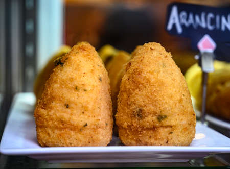 Tasty italian street food, deep fried aranchini rice balls with different filling close upの写真素材