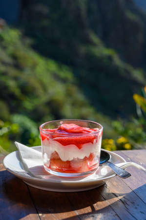 Sweet dessert, cheese cake with mousse and red prickly pears jam served in glass