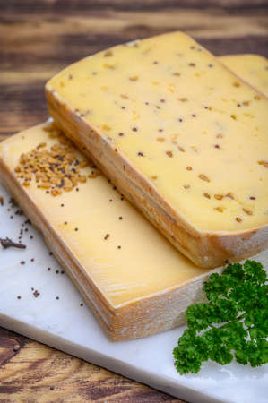 Belgian cheeses from abbey made from cow milk with monks beer, fenugreek and mustard seeds close up