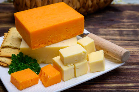 British hard cheeses made from cow milk yellow matured cheddar from Somerset and red leicester