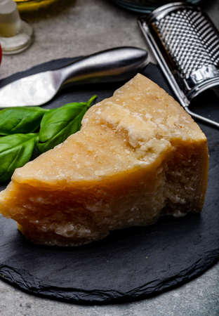 Cheese collection, piece of hard aged Italian parmesan or grana padano cheese with knife, olive oil...