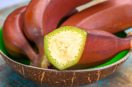 Bunch of ripe red bananas close up in bowlの写真素材