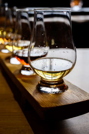 Flight of Scottish whisky, tasting glasses with variety of single malts or blended whiskey spirits on distillery tour in Scotland, UKの写真素材