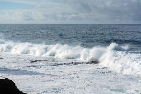 Dangerious ocean stormy waves hits black lava rocks by Faro de las Hoyas, La Palma island, Canary,...