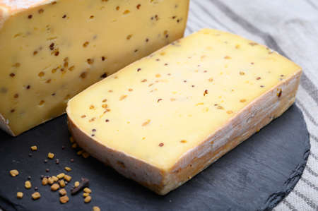 Belgian cheeses from abbey made from cow milk with monks beer, fenugreek and mustard seeds close up