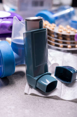 Different medicaments for asthma threatment, pills, inhalers, blood test-tubes and syringe, hospital background close upの写真素材