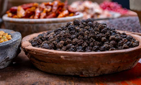 Indian spices collection, dried black peppercorns  and another spices in clay bowls close upの写真素材