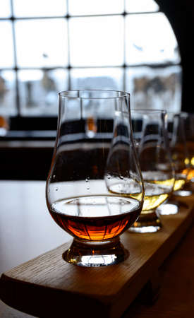 Flight of Scottish whisky, tasting glasses with variety of single malts or blended whiskey spirits...