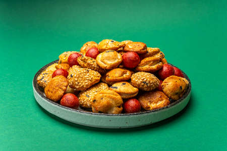 Tasty asian vegetarian appetizer, crunchy rice en peanuts snacks from Japan on green background