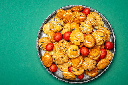 Tasty asian vegetarian appetizer, crunchy rice en peanuts snacks from Japan on green backgroundの写真素材