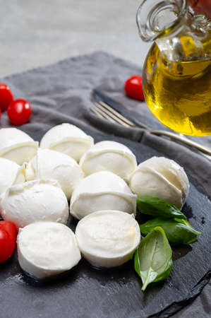 Tasty italian food, fresh white buffalo mozzarella soft cheese balls from Campania and tomatoes,...