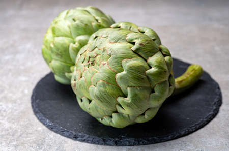 Big ripe uncooked green globe artichoks vegetables close upの写真素材
