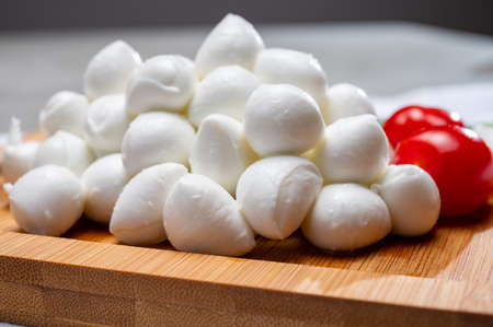 Italian food, fresh fresh green basil, white mini mozzarella cheese and red cherry tomatoes close upの写真素材