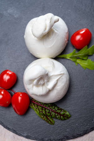 Cheese collection, fresh soft white burrata cheese ball made from mozzarella and cream from Apulia, Italy, close upの写真素材