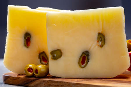 Cheese collection, fresh Italian pecorino cheese made from sheep milk filled with green olives stuffed with red sweet paprikaの写真素材