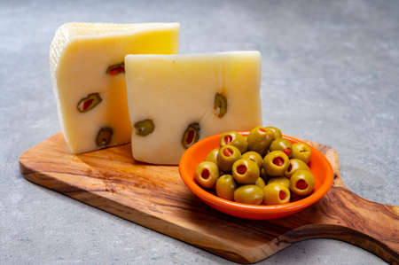 Cheese collection, fresh Italian pecorino cheese made from sheep milk filled with green olives stuffed with red sweet paprikaの写真素材