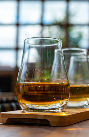 Tasting of different Scotch whisky drinks in traditional old British house with wooden windowsの写真素材