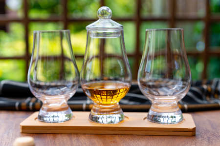 Tasting of different Scotch whisky drinks in traditional old British house with wooden windowsの写真素材