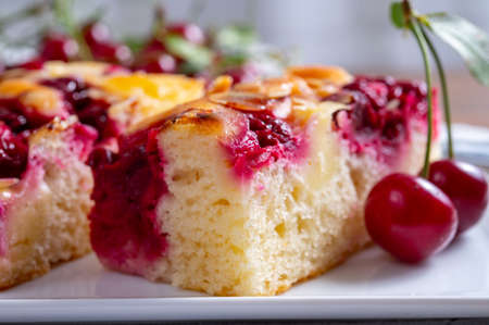 Fresh baked cake with red ripe juicy sour cherry or kriek berry close up