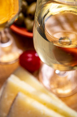 Glasses of dry cold fino sherry wine served with spanish tapas, manchego cheese, green olives, cheese crackersの写真素材