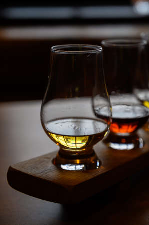 Flight of Scottish whiskey, tasting glasses with variety of single malts or blended whiskey spirits...
