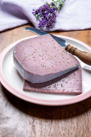 Cheese collection, pieces of violet hard cheese made with aromatic lavender seeds and fresh lavender...