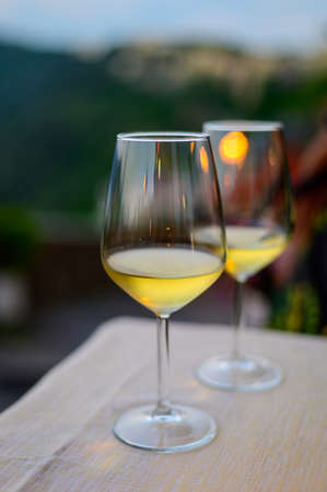 Two glasses of cold dry white wine served outdoor in cafe at night in Italy close upの写真素材