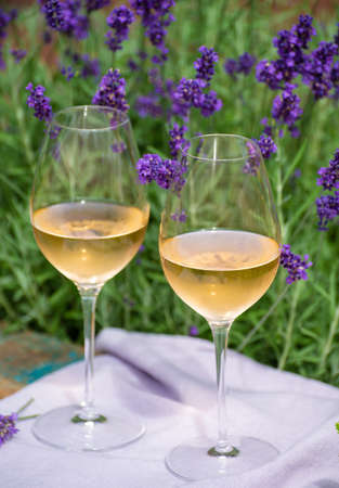 Love Provence, romantic picnic with two glasses of cold French rose wine and purple lavender flowers...