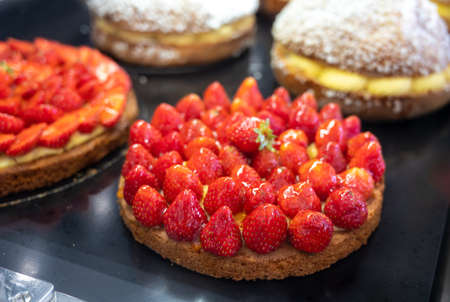Assortment of french fresh baked sweet pastry with fresh fruits and berries in confectionery shop close upの写真素材