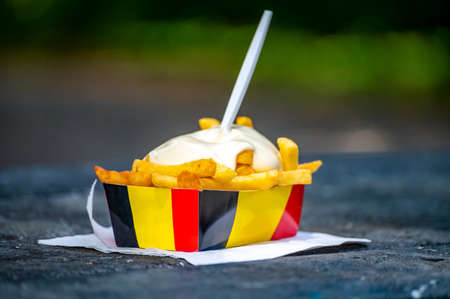 Belgian street and fast food, paper box in colors of Belgian flag with fried potato frit chips and mayonnaise sauÑe.の写真素材
