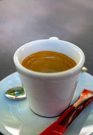 Drinking of strong black espresso coffee on outdoor terrace in cafe close up