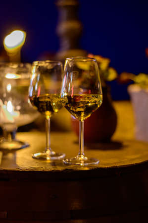 Two glasses of cold dry white wine served outdoor in cafe at night in Italy close up