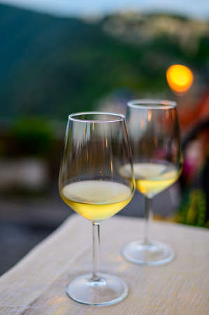 Two glasses of cold dry white wine served outdoor in cafe at night in Italy close upの写真素材