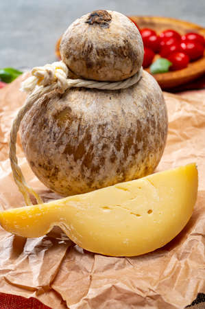 Italian semi hard matured caciocavallo cheese, handmade and aged in natural underground caves in...