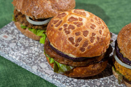 Healthy vegan or vegetarian fast food, fresh made plant based burgers with vegetables close upの写真素材