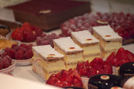 Assortment of french fresh baked sweet pastry with fresh fruits and berries in confectionery shop...