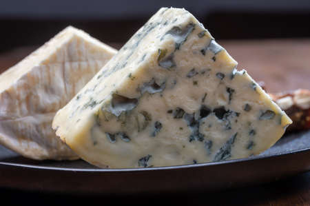 Cheese collection, blue cheese, camembert, brie served as dessert with fig almonds bread close up